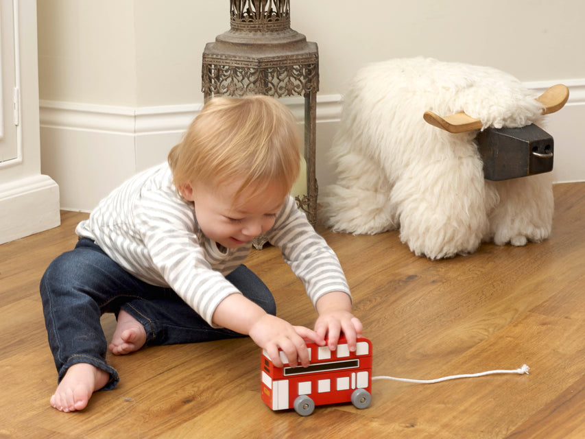 London bus pull along lifestyle image wooden toy with small child playing indoors